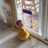 Baby playing with Violet Busy Baby Mini Mat silicone mat attached to sliding glass door