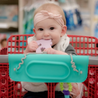 Baby teething on toy connected to Tethers with the Spearmint Busy Baby Mat silicone mat wrapped around shopping cart handle