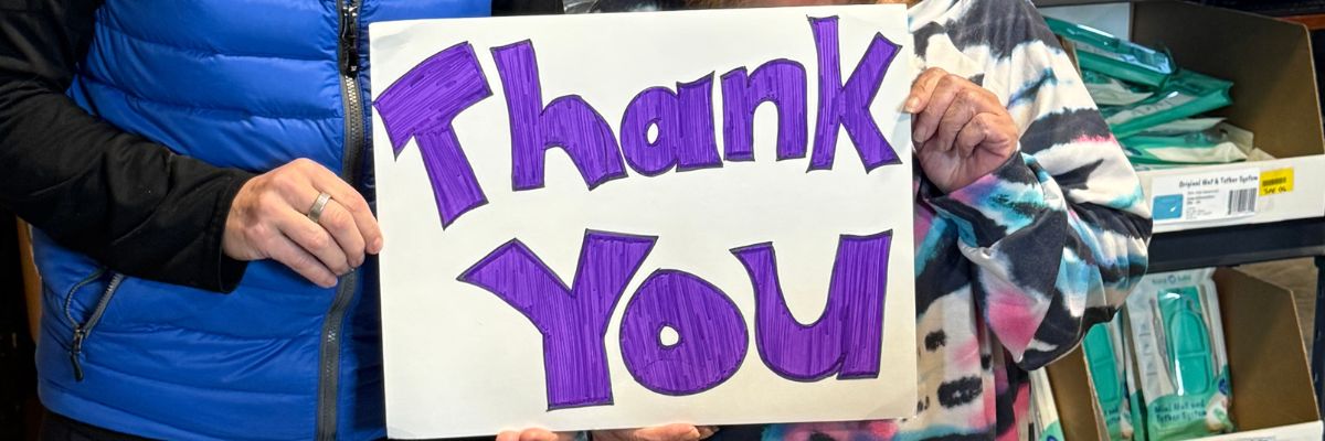 Beth Benike and employee with a thank you sign in the Busy Baby Warehouse