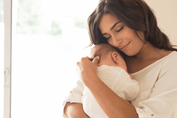 mom holding newborn baby postpartum