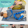 A baby sitting in a highchair with Busy Baby Sloth Teether Attached to the Busy Baby oy Bungee that is attached to the busy baby original mat