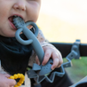 Busy Baby pewter teething spoon and toy bungee with baby chewing on teething spoon