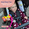 A baby is in a stroller holding a Toy that is attached with the Busy Baby Toy Bungee to the stroller handle.