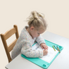 Child tracing with crayons on Busy Baby Toddler Mat