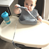 Baby with Busy Baby Bib and Utensils pulling on Fork and Tether