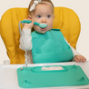 Baby in highchair eating on Busy Baby Mat silicone Mat with Busy Baby Utensils